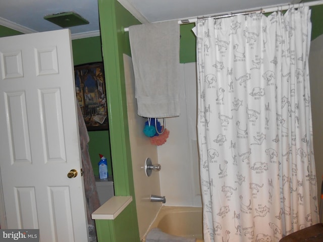 bathroom featuring ornamental molding and shower / bath combo with shower curtain