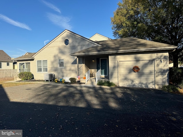 back of house with a garage and central AC