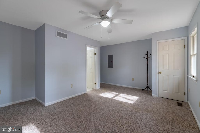 unfurnished room with electric panel, light colored carpet, and ceiling fan