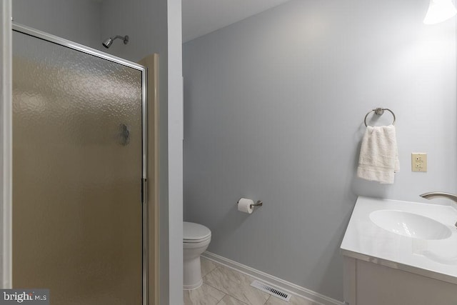 bathroom featuring toilet, vanity, and a shower with door