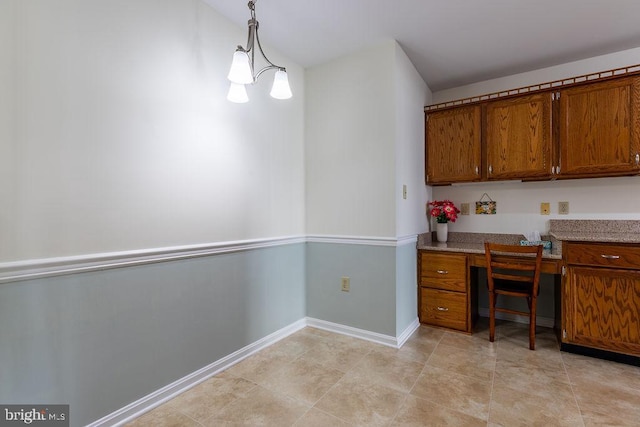 interior space featuring hanging light fixtures, built in desk, light tile patterned flooring, and a notable chandelier