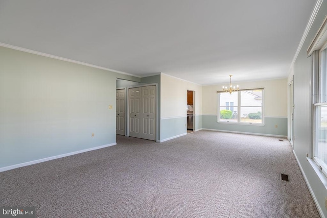 unfurnished room with light carpet, ornamental molding, and a notable chandelier