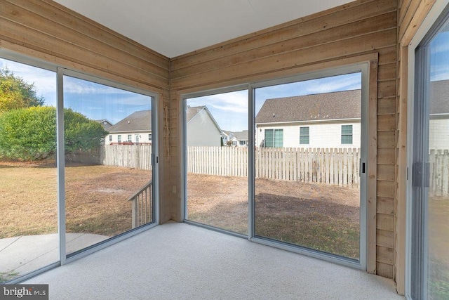 entryway with carpet floors and wooden walls