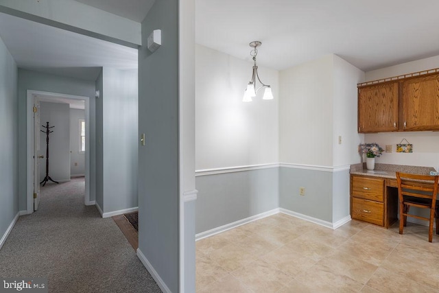 kitchen with an inviting chandelier, decorative light fixtures, and light carpet