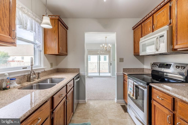 8 Crossgate Dr Unit 8, Seaford, DE 19973 - kitchen featuring appliances with stainless steel finishes, a sink, brown cabinets, and decorative light fixtures