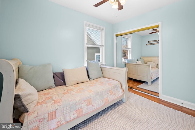 bedroom with hardwood / wood-style floors, ceiling fan, and a closet