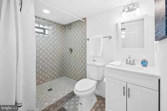 bathroom featuring toilet, vanity, and a tile shower