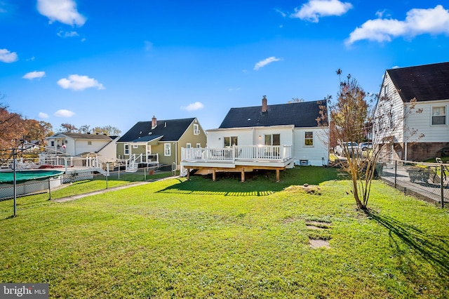 rear view of house featuring a deck and a lawn