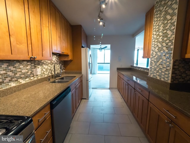 kitchen with sink, dark stone counters, dishwasher, and white refrigerator