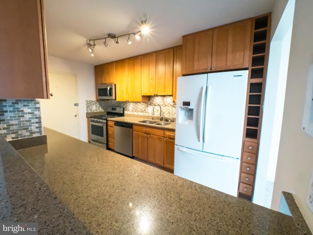 kitchen with appliances with stainless steel finishes, sink, and decorative backsplash