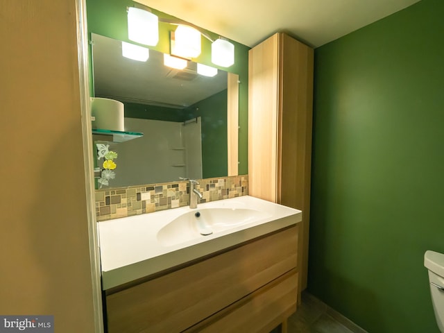 bathroom with tasteful backsplash, vanity, and toilet