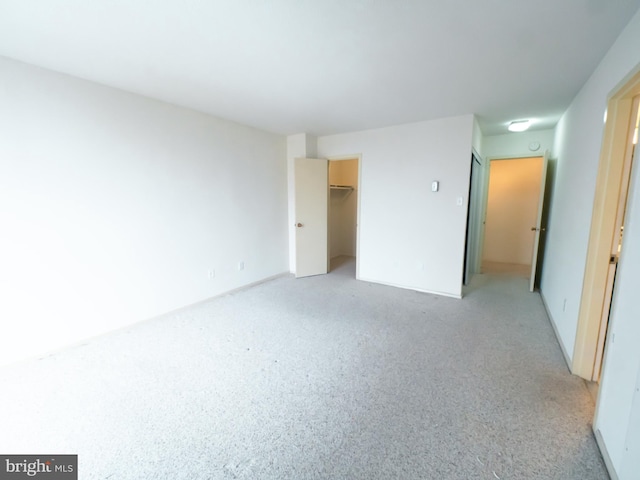 unfurnished bedroom featuring a spacious closet and a closet