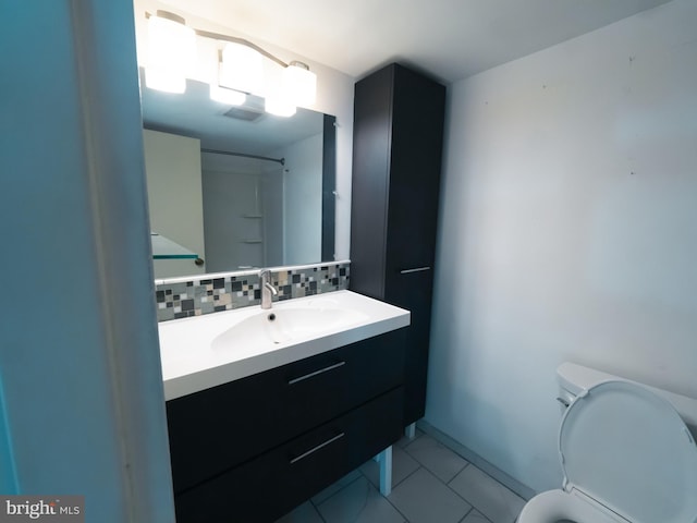 bathroom featuring vanity, backsplash, tile patterned floors, and toilet