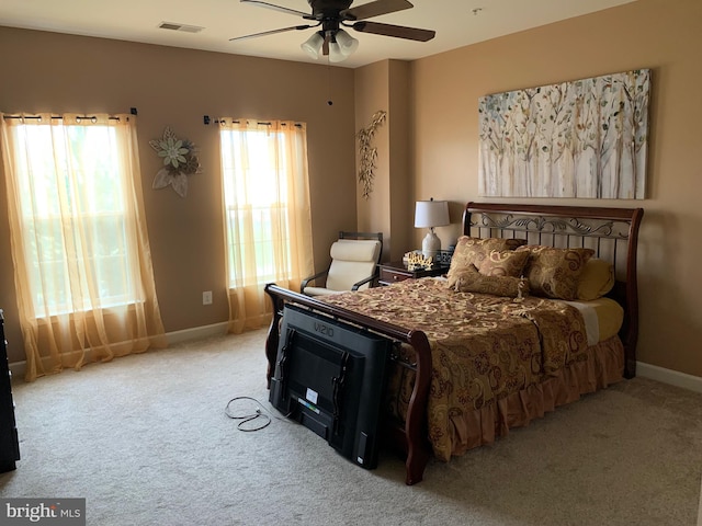 bedroom featuring light colored carpet, multiple windows, and ceiling fan