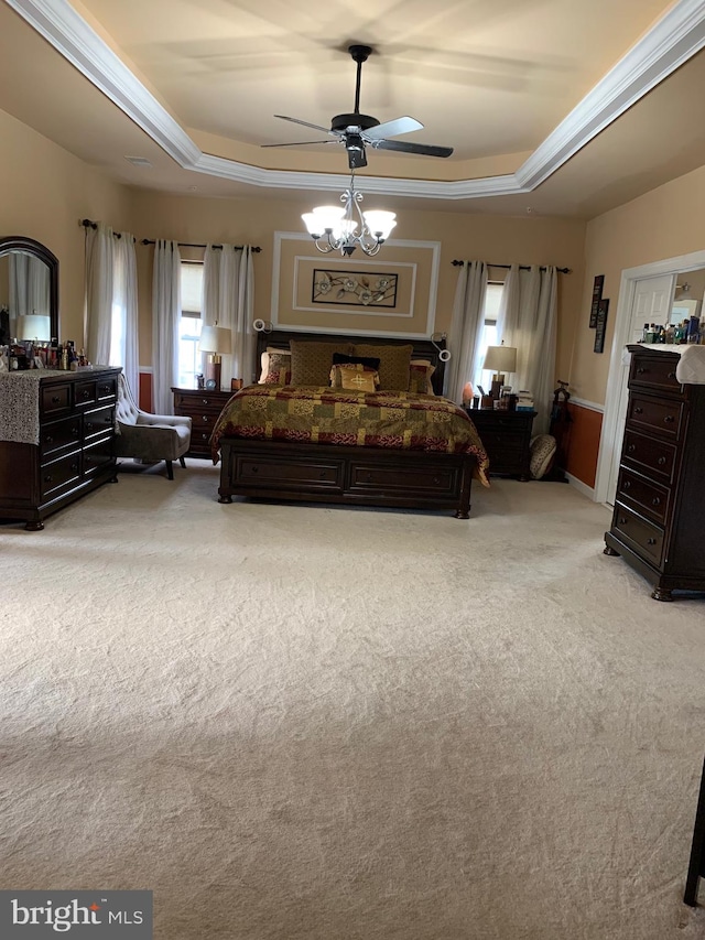 carpeted bedroom featuring a raised ceiling, ceiling fan, and ornamental molding