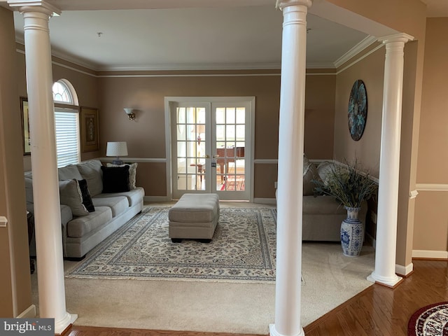 living room with a wealth of natural light, french doors, wood-type flooring, and ornamental molding