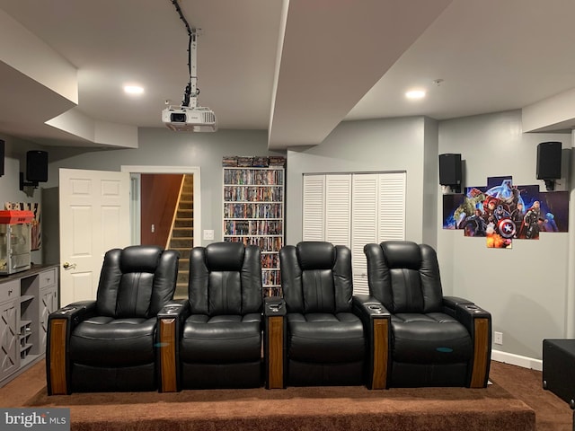 home theater room with carpet floors and rail lighting