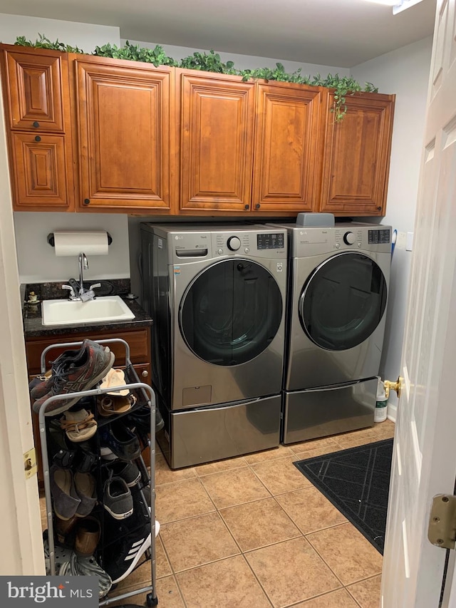 clothes washing area featuring cabinets, separate washer and dryer, light tile patterned flooring, and sink