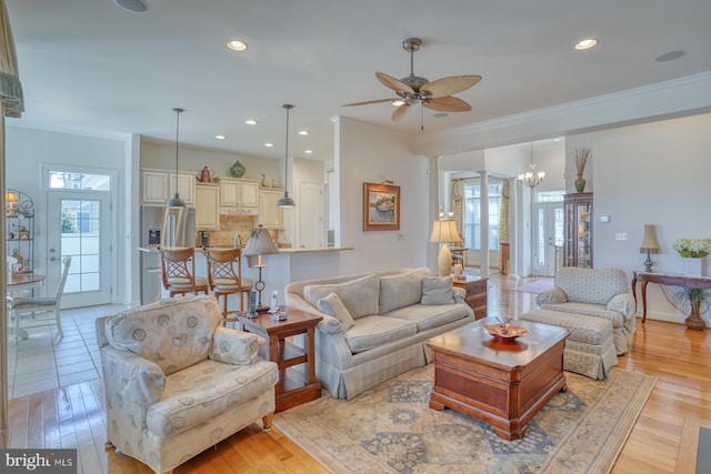 living room with ornamental molding, recessed lighting, and light wood-style flooring