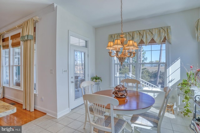 dining room with light tile patterned floors, baseboards, and an inviting chandelier