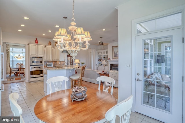 dining area featuring recessed lighting, a toaster, a fireplace, and light tile patterned floors