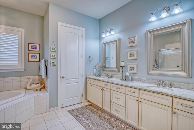 full bathroom with a relaxing tiled tub, tile patterned flooring, a sink, and double vanity