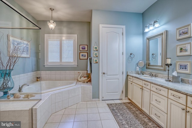 bathroom featuring a garden tub, vanity, and tile patterned floors