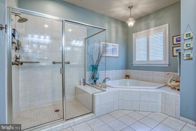 bathroom featuring a stall shower, a bath, and tile patterned floors