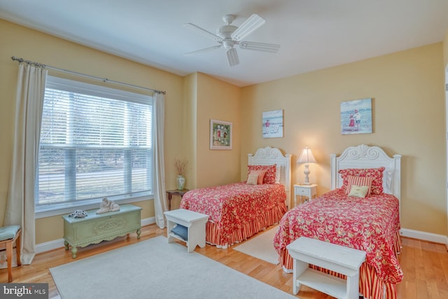 bedroom with a ceiling fan, baseboards, and wood finished floors