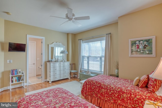 bedroom with ceiling fan, wood finished floors, and baseboards