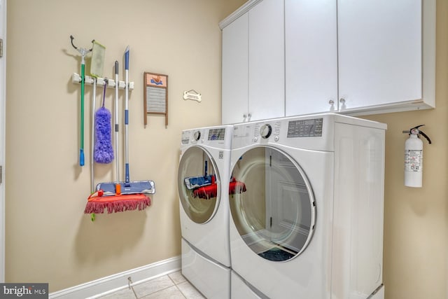 laundry room featuring cabinet space, light tile patterned floors, baseboards, and independent washer and dryer