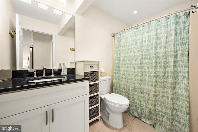 bathroom featuring vanity, tile patterned floors, and toilet