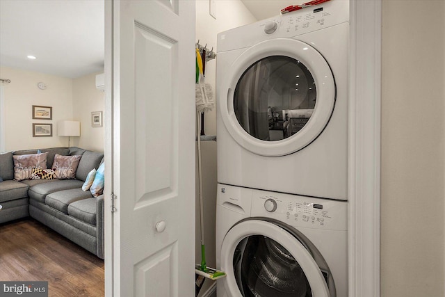 clothes washing area with dark wood-type flooring and stacked washer / drying machine