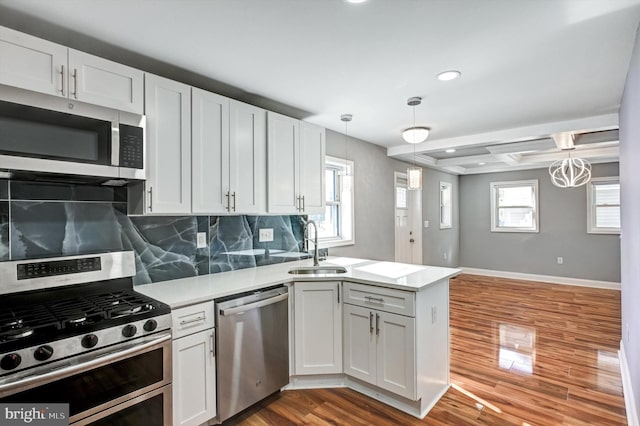 kitchen with hardwood / wood-style floors, white cabinetry, pendant lighting, and appliances with stainless steel finishes