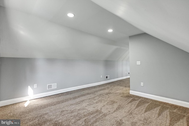 additional living space with carpet flooring and lofted ceiling