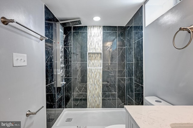 bathroom with vanity, toilet, and a tile shower