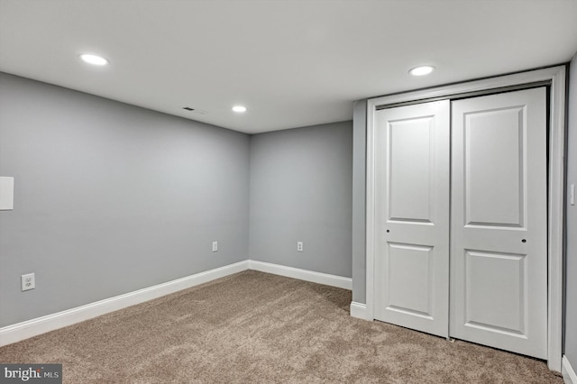 unfurnished bedroom featuring a closet and light carpet