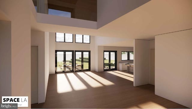 interior space featuring a towering ceiling, french doors, and dark wood-type flooring