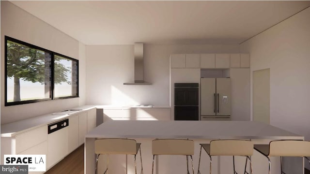 kitchen featuring wall chimney range hood, white cabinets, a kitchen bar, dark hardwood / wood-style floors, and white refrigerator