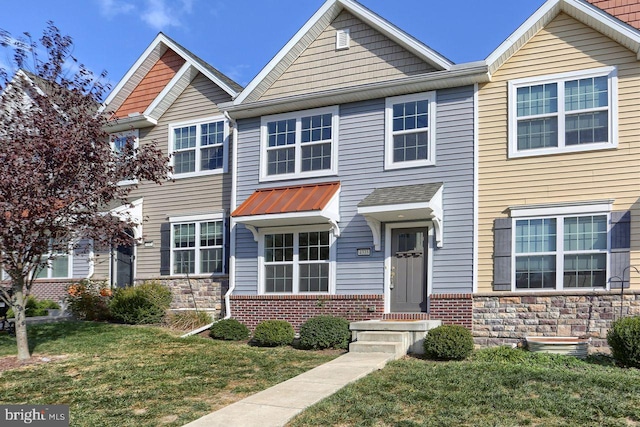 townhome / multi-family property featuring a front lawn