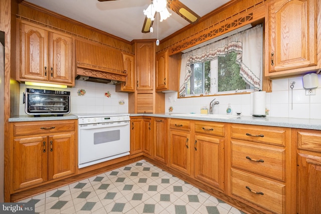 kitchen with sink, ceiling fan, white range oven, custom exhaust hood, and decorative backsplash