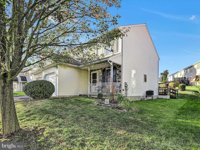 view of front of property featuring a porch, a front yard, and a garage