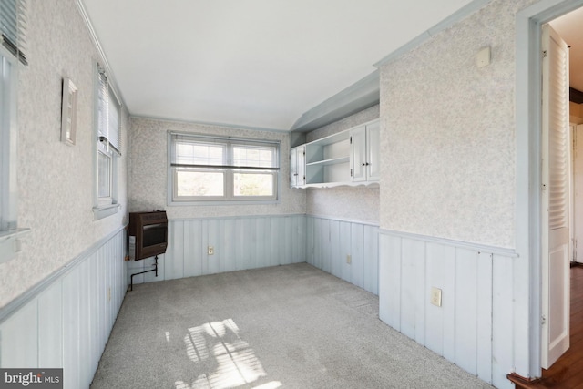 interior space with light colored carpet, heating unit, and crown molding