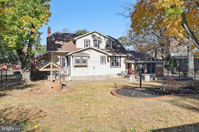 back of house with a lawn and a sunroom