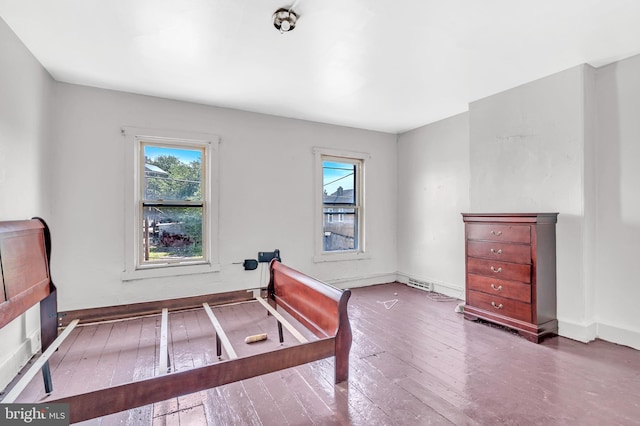 bedroom with multiple windows and hardwood / wood-style floors