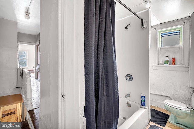 bathroom featuring shower / bath combo, hardwood / wood-style floors, and toilet