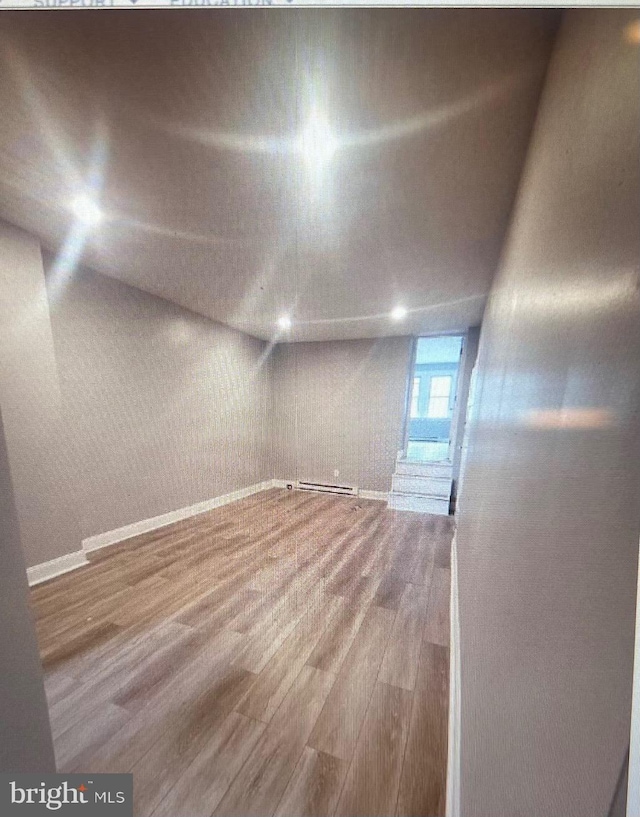 spare room with hardwood / wood-style flooring and baseboard heating