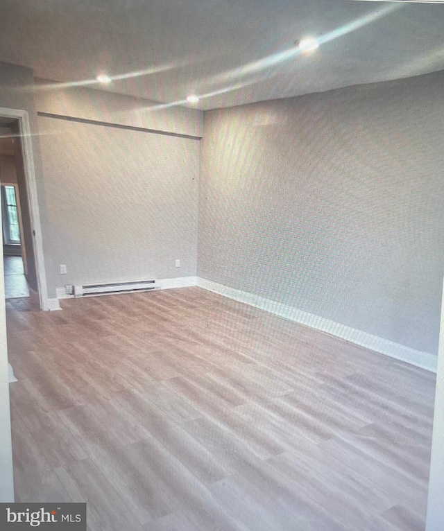 5514 Lansdowne Ave, Philadelphia, PA 19131 - below grade area with a baseboard heating unit, baseboards, and wood finished floors