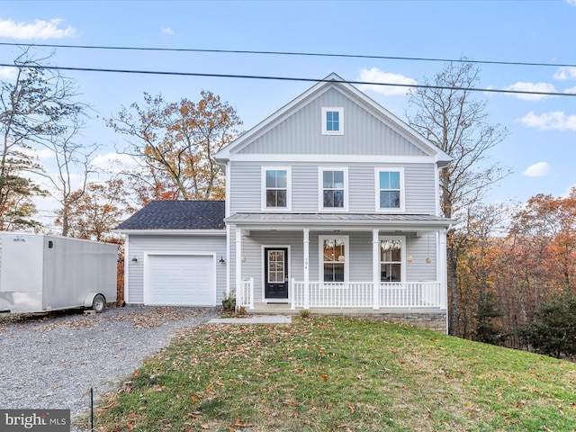 view of front facade featuring a front lawn, covered porch, and a garage