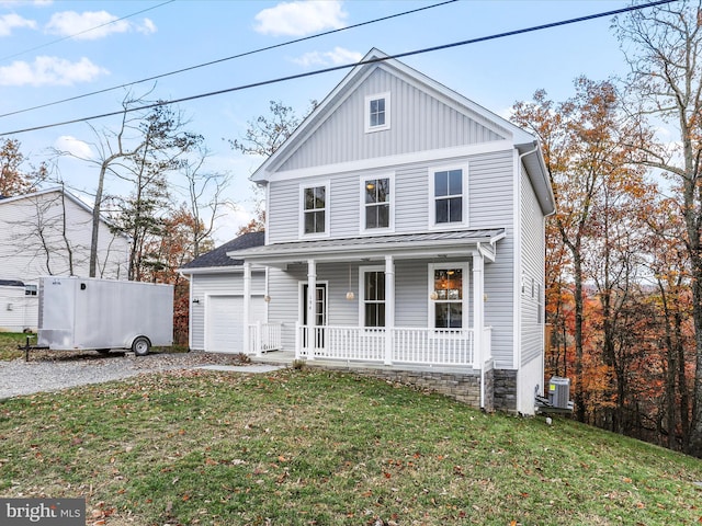 front facade featuring a garage, a front lawn, central air condition unit, and a porch